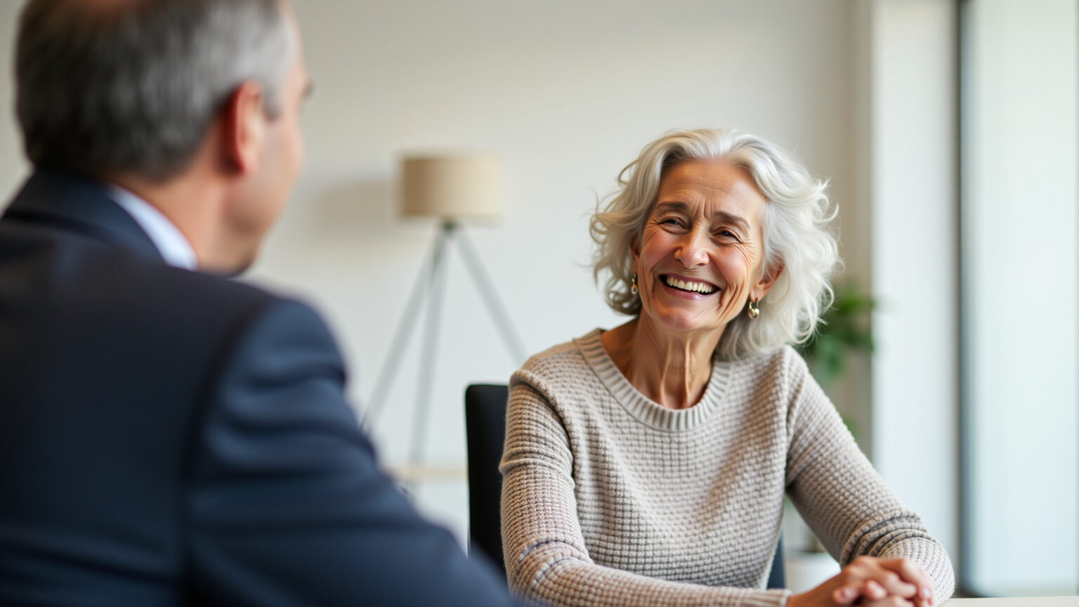 Idosa sorrindo conversando com agente de plano de saúde.